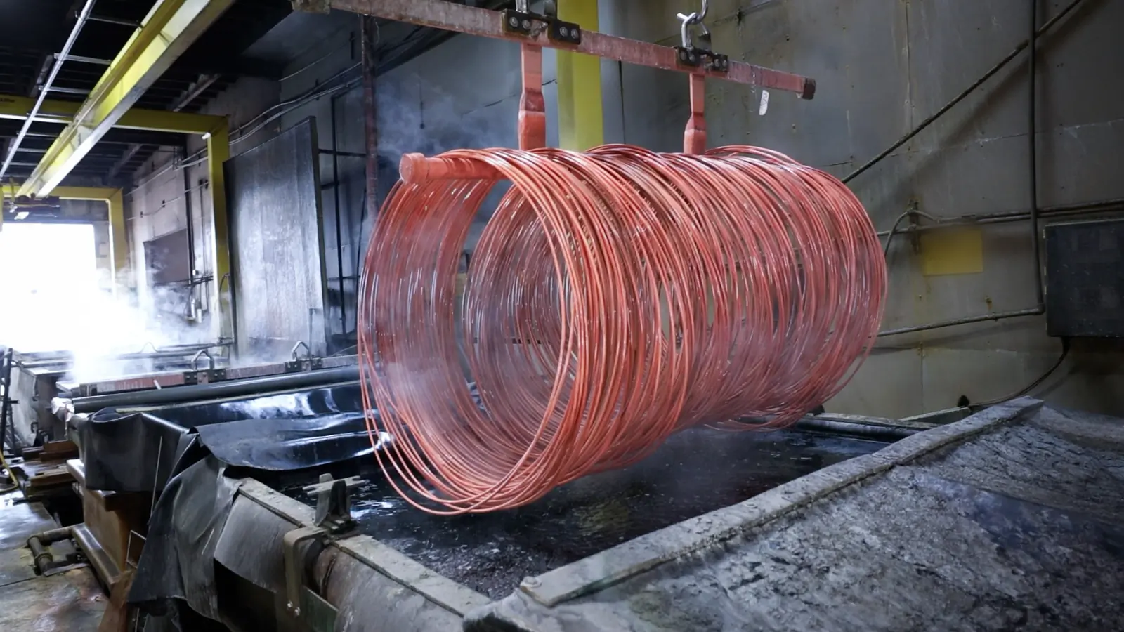 A freshly copper-coated coil of wire coming out of the plating bath
