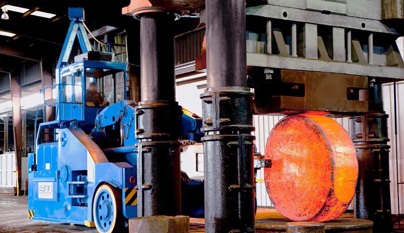 A glowing open-die forging between the columns of the 6,500-ton press at Forged Products