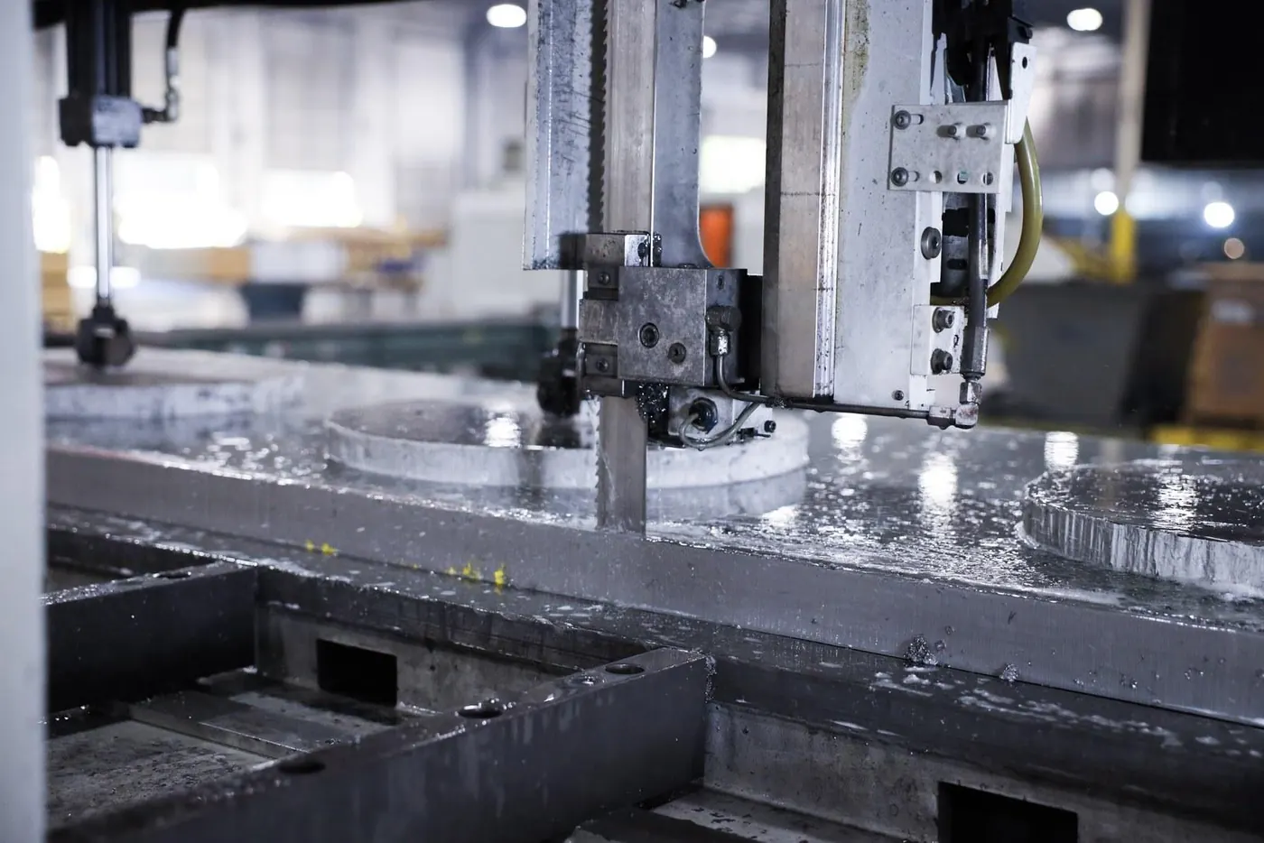 A saw cutting round blanks out of a titanium plate